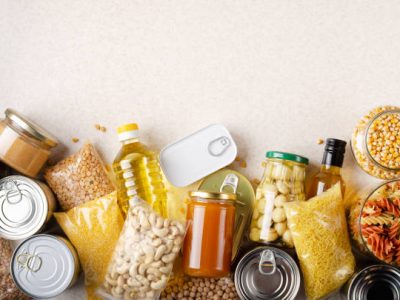 Flat lay view at kitchen table full with non-perishable foods. Spase for text