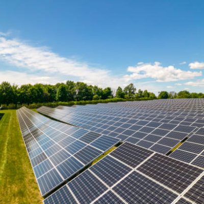 View of modern photovoltaic solar panels to charge battery. Rows of sustainable energy solar panels set up on the farmland. Green energy and environment ecology concept.